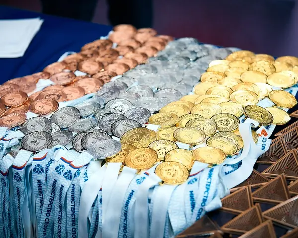 Золотые, серебряные и бронзовые медали на лентах разложены на столе перед награждением